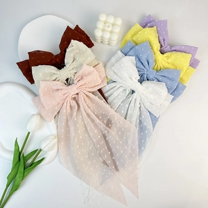 Close-up of chiffon polka dot hair bows in various colors with elegant long ribbons