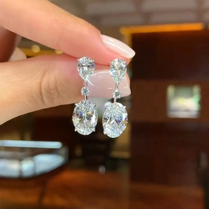 Macro detail of silver drop earrings featuring oval and pear-cut crystal stones