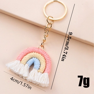 Handmade woven rainbow keychain in pastel pink and blue with size specs and golden ring
