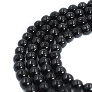 Macro shot of polished black agate round beads with glossy finish for jewelry making