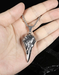 Detailed close-up of a silver crow skull pendant with Nordic runes on a box chain