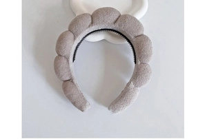 Detail of light gray sponge headband with textured fabric and non-slip inner teeth
