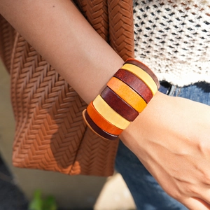 Close-up of wide wooden bead bracelet with colorful geometric slices on wrist
