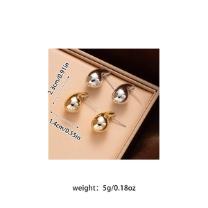 Detail view of gold and silver bean earrings with size 2.3cm and weight 5g dimensions