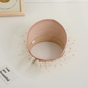 Detail of pink straw sun hat for kids featuring lace trim and adjustable elastic strap