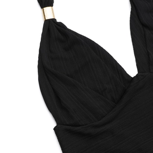 Détail du tissu plissé noir avec boucle en métal doré et finitions de couture précises