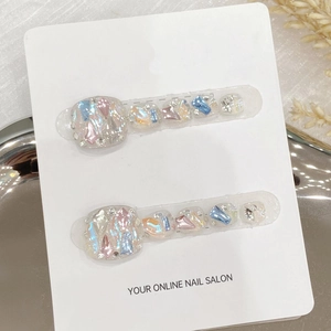 Uñas postizas artesanales para pies con purpurina iridiscente y pedrería en tarjeta blanca