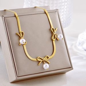 Elegant gold snake chain necklace featuring bowknot pendants and white pearls for women