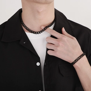 Polished black Cuban link necklace and bracelet set displayed on a male model