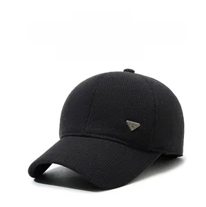 Detail of black winter baseball cap with knit texture and metal triangle badge logo