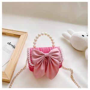 Detailed view of a pink woven mini handbag with a pearl handle and a large satin bow accent