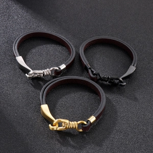 Detail of leather bracelets with gold, silver, and black metal hooks on black background