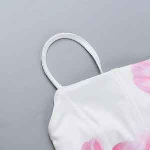 Detail of pink floral print on white woven fabric with slim spaghetti strap design
