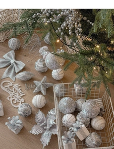 Silver and white Christmas tree ornaments including glitter balls, stars, and bow ties