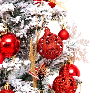 Christmas ball ornaments with red glitter hollow balls and gold reindeer on snowy tree