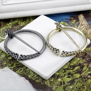 Macro detail of vintage Viking brooches in gold and silver finish with Celtic knot patterns