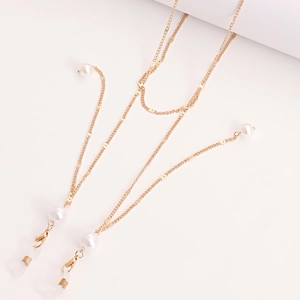 Detail of gold eyewear chain with butterfly beads, white pearls and lobster clasps