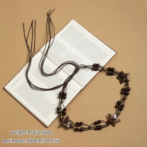 Détail de la chaîne de taille bohème marron avec perles en bois sur livre ancien