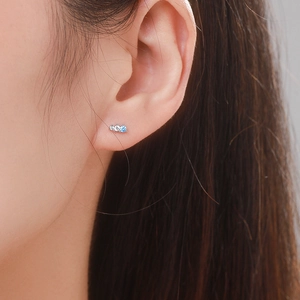 Minimalist S925 sterling silver stud earrings with blue zircon crystals on ear