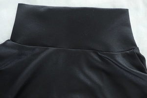 Detail of high-waist black yoga pants showing premium elastic fabric and stitching