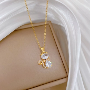 Macro d'un pendentif chat doré avec zircon transparent sur un tissu en soie doux