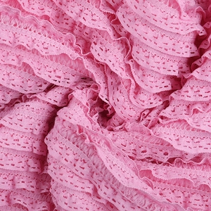Gros plan sur le tissu jacquard rose texturé avec dentelle délicate et détails plissés