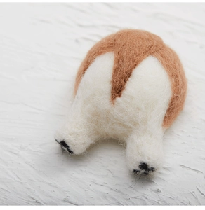 Detail shot of a handmade wool felt Corgi butt ornament with realistic brown white texture