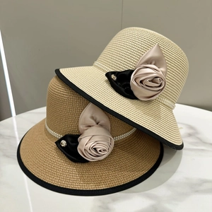 Détails de chapeaux de paille avec bande de perles et élégantes fleurs de camélia