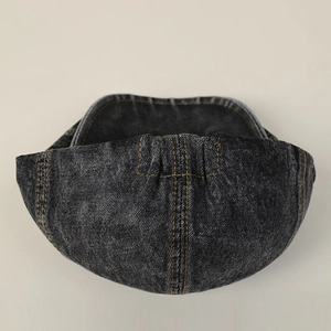 Detail of dark denim ivy cap showing contrast stitching and elastic back adjustment