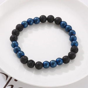 Detailed macro view of 8mm black volcanic lava stones and blue metallic beads on a bracelet