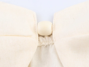 Close-up of beige cotton linen fabric and round button detailing on the resort set