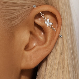 Macro shot of industrial barbell featuring sparkling zircon butterfly on silver s925 pole