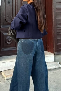 Detailed back view of navy blue cropped vest and wide-leg denim jeans with unique pockets