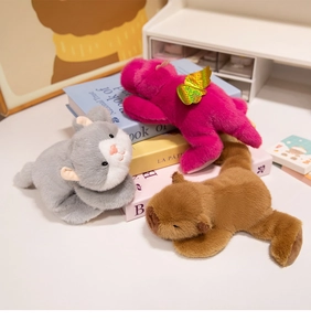 Close-up of soft plush toys including a pink unicorn and brown capybara on a cozy desk
