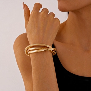 Close-up of golden multi-layer snake bone textured bracelet with metallic finish