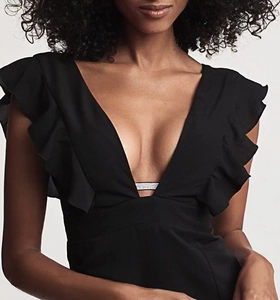 Detail view of rhinestone embellishment and deep V-neckline on a black backless dress