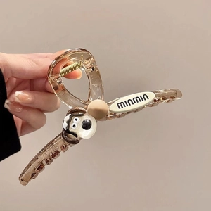 Detail of cute transparent brown puppy hair claw clip with minmin label and dog motif
