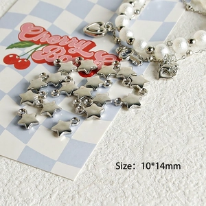 Macro shot of 10x14mm silver star charms for Y2K jewelry DIY on a checkered card