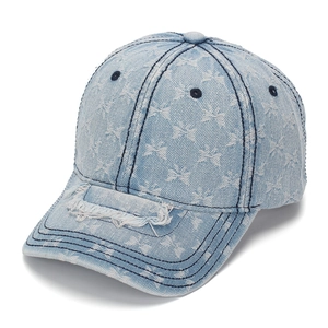 Detail of light blue distressed denim baseball cap featuring white butterfly patterns