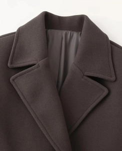 Detailed close-up of dark coffee wool coat lapel showcasing premium fabric texture