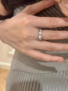 Detailed view of an S925 silver twist ring with elegant pearls on a model's hand