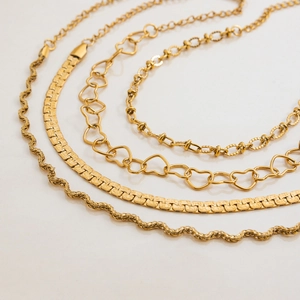 Four-piece 18K gold-plated stainless steel chain set featuring heart and flat link designs