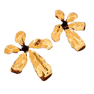 Golden flower earrings with hammered metal texture and black bead center on white background