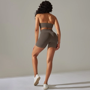Dettaglio del tessuto a maglia a coste senza cuciture su pantaloncini yoga e reggiseno taupe