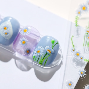 Thin self-adhesive nail stickers with daisy floral patterns in light blue and purple