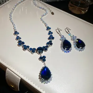 Elegant jewelry set with teardrop blue sapphire pendant necklace and matching earrings