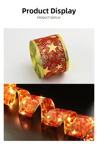 Detail of red Christmas ribbon with gold stars and warm white LED lights effect