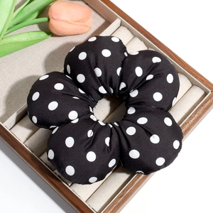 Detail of a large floral scrunchie in black and white polka dot fabric on a tray