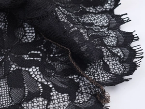 Macro shot of delicate black floral eyelash lace fabric showing fine mesh textures
