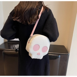 Funny skull crossbody bag with pink heart eyes and adjustable strap worn by a model